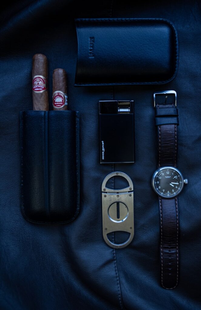 Cigars, watch, lighter, cutter, and case lie on display.